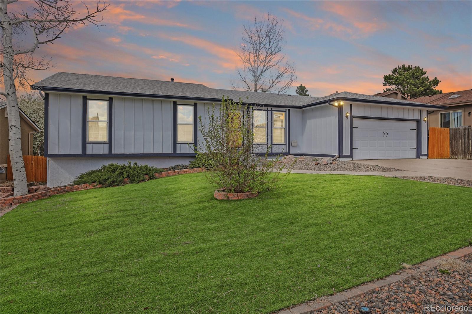 2970 Downhill Drive Colorado Springs, CO 80918 - Photo 1 of 27 a front view of a house with a garden and yard
