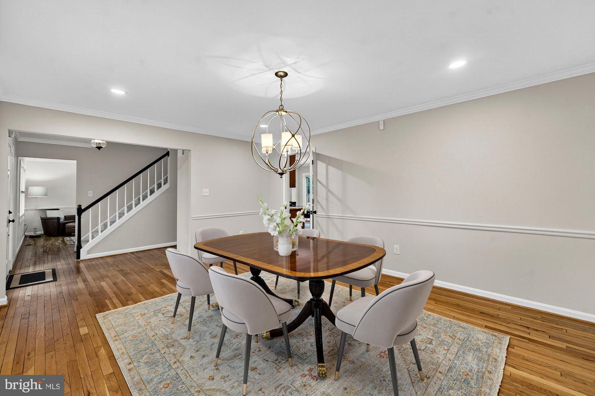 930 Park Street Vienna, VA 22180 - Photo 15 of 83 a dining room with wooden floor a chandelier a glass table and chairs