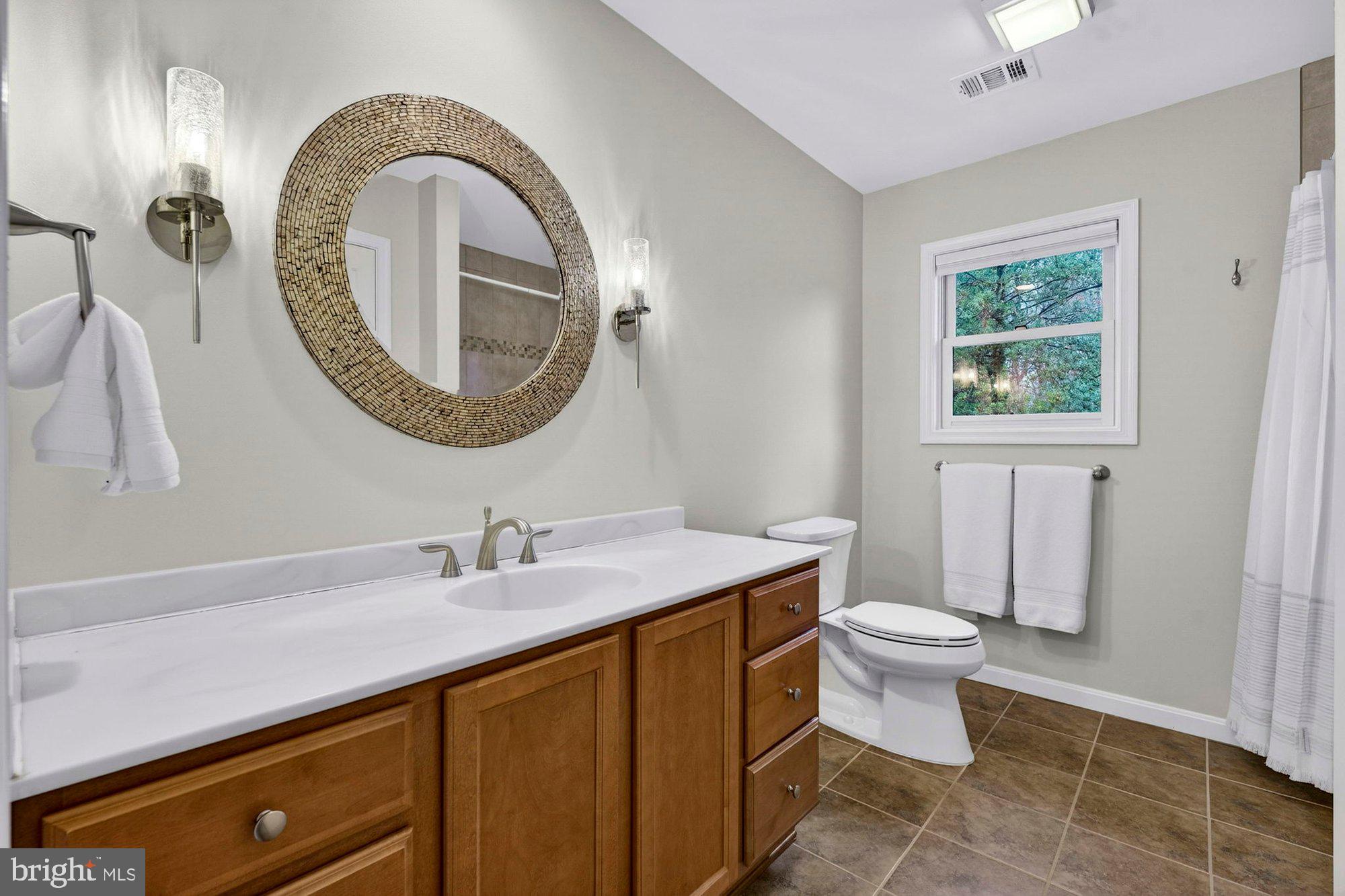 930 Park Street Vienna, VA 22180 - Photo 54 of 83 a bathroom with a granite countertop toilet a sink and a mirror