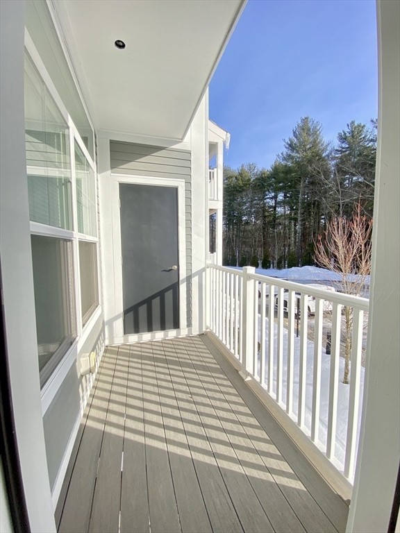 635 Old Post Road, Unit 2203 Sharon, MA 02067 - Photo 18 of 40 a bedroom with a bed and wooden floor