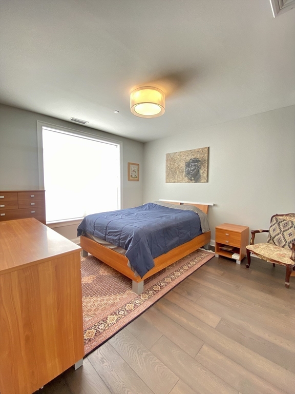 635 Old Post Road, Unit 2203 Sharon, MA 02067 - Photo 20 of 40 a bedroom with a bed and wooden floor