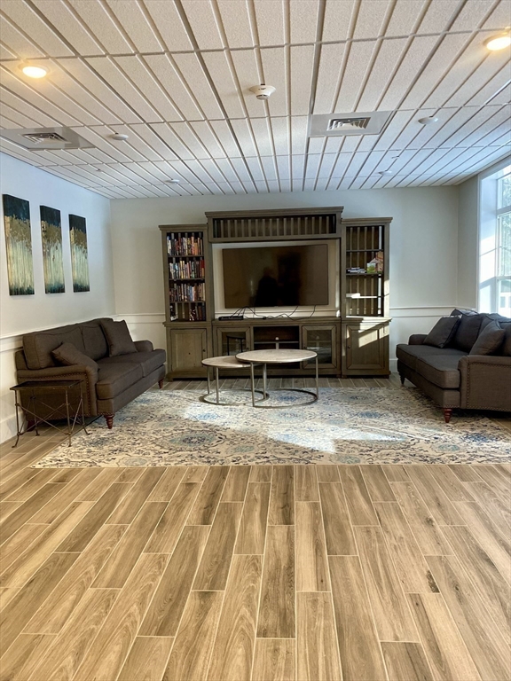 635 Old Post Road, Unit 2203 Sharon, MA 02067 - Photo 30 of 40 a living room with furniture a flat screen tv and gym equipment