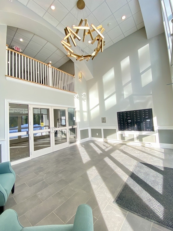 635 Old Post Road, Unit 2203 Sharon, MA 02067 - Photo 32 of 40 a living room with a large window and chandelier