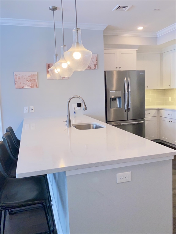 635 Old Post Road, Unit 2203 Sharon, MA 02067 - Photo 7 of 40 a kitchen with a table chairs and refrigerator