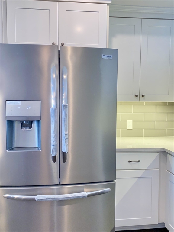 635 Old Post Road, Unit 2203 Sharon, MA 02067 - Photo 8 of 40 a view of a kitchen with white cabinets and a refrigerator