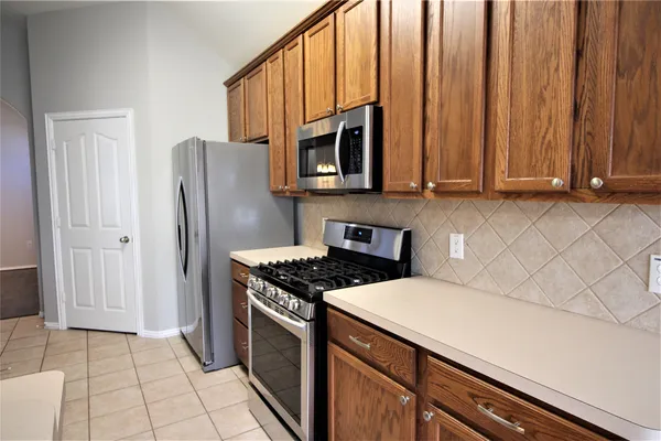 a kitchen with stainless steel appliances a stove a microwave and a sink