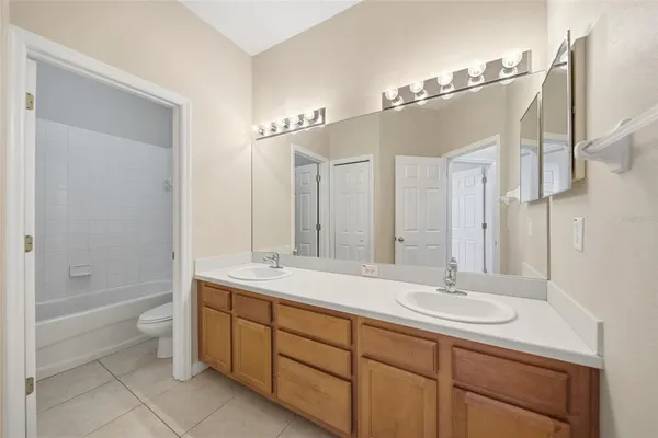 a bathroom with a double vanity sink mirror double and bathtub