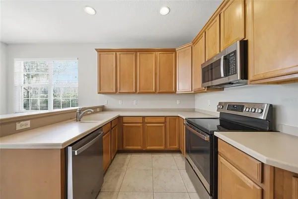 a kitchen with stainless steel appliances granite countertop a sink stove and microwave