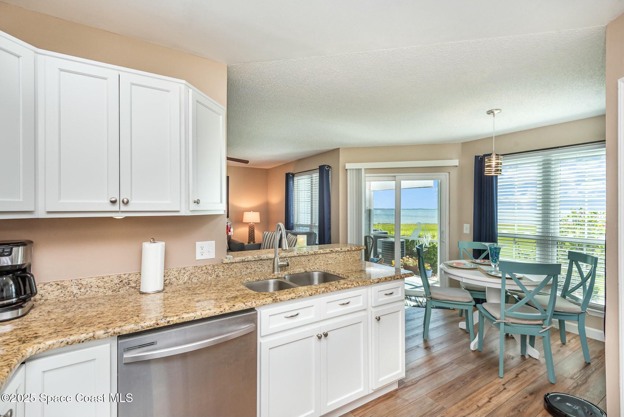 7300 N Highway, Unit 104 Cocoa, FL 32922 - Photo 1 of 33 a kitchen with granite countertop white cabinets and white appliances