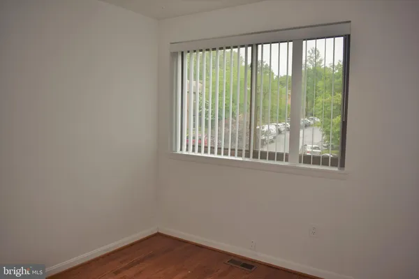 a view of a small space with wooden floor and a window