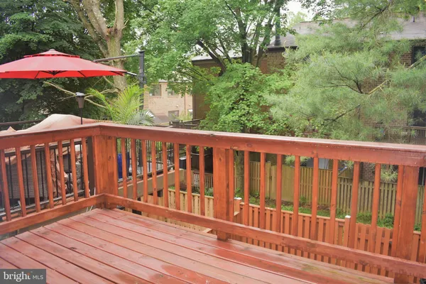 a balcony with wooden floor and yard in the back