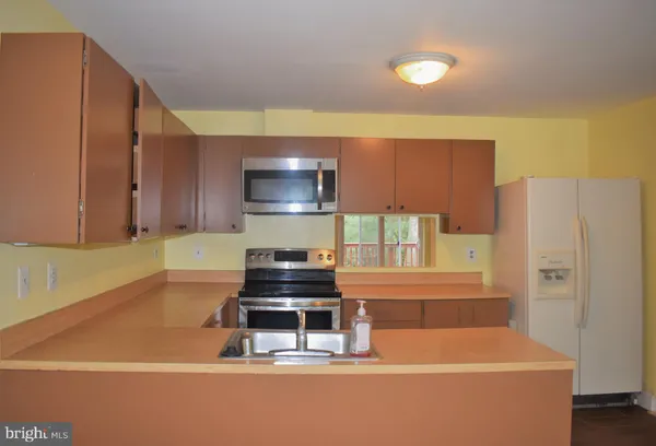 a kitchen with stainless steel appliances a refrigerator and a stove top oven