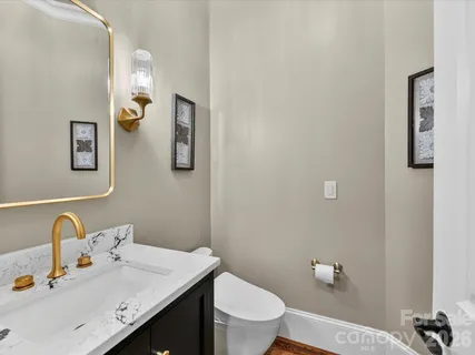 a bathroom with a granite countertop toilet sink and mirror