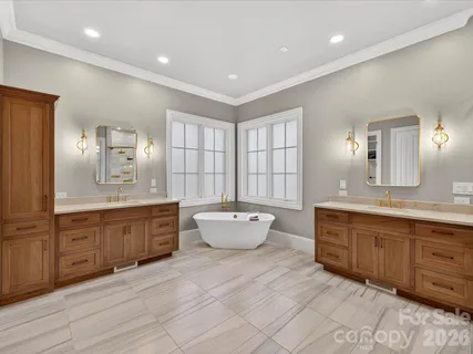 a large bathroom with a large tub sink and mirror
