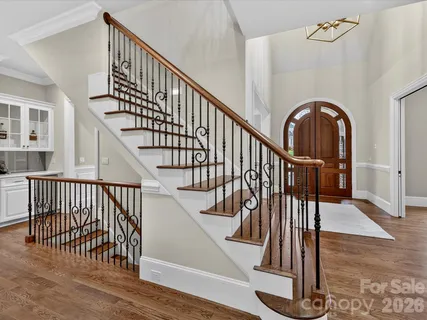 a view of staircase with wooden floor and a chandelier