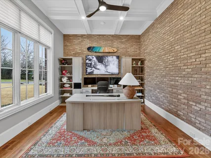 a view of living room with furniture wooden floor and wall paintings