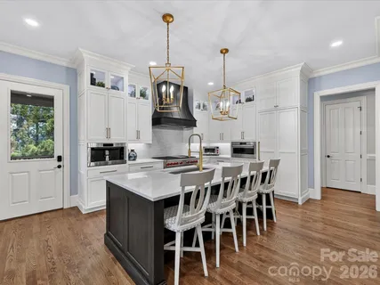 a view of a dining room and livingroom with furniture wooden floor a chandelier