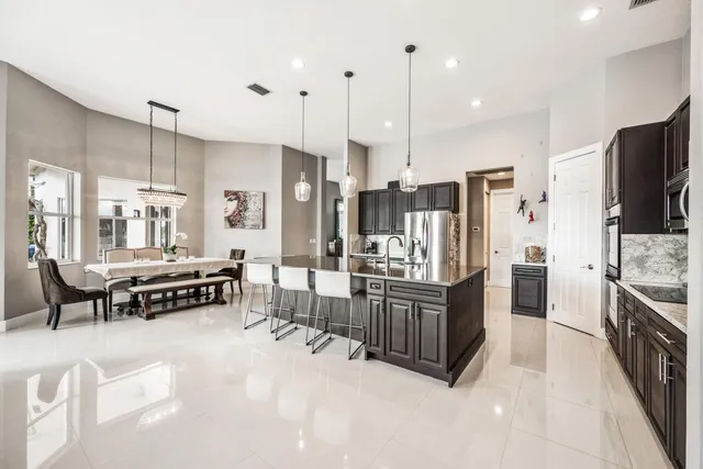 a bathroom with a granite countertop toilet a sink a mirror and a shower