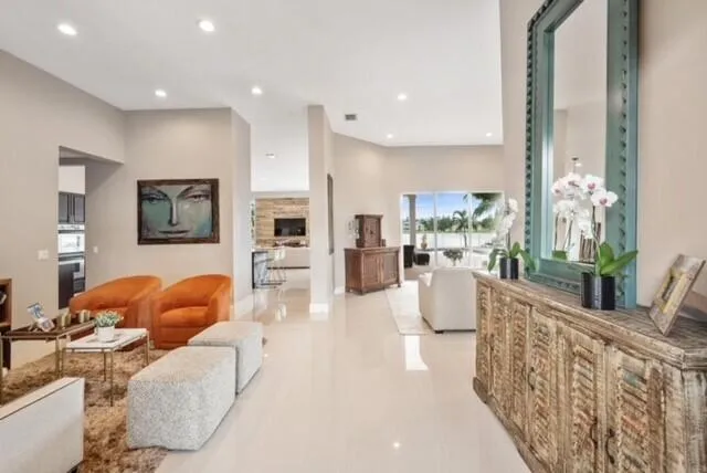 a kitchen with stainless steel appliances kitchen island granite countertop a refrigerator a stove a sink a kitchen island with chairs and white cabinets