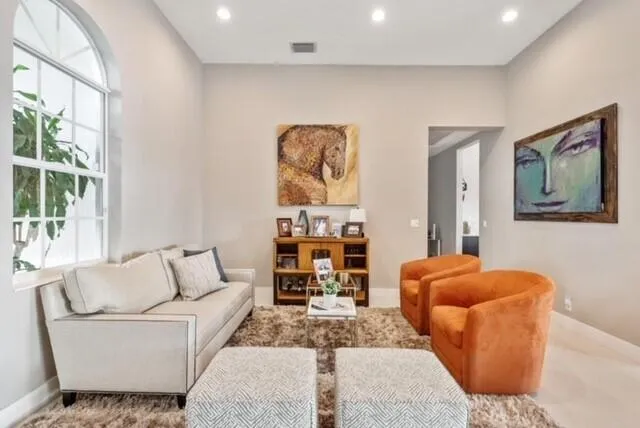 a living room with furniture kitchen view and a large window