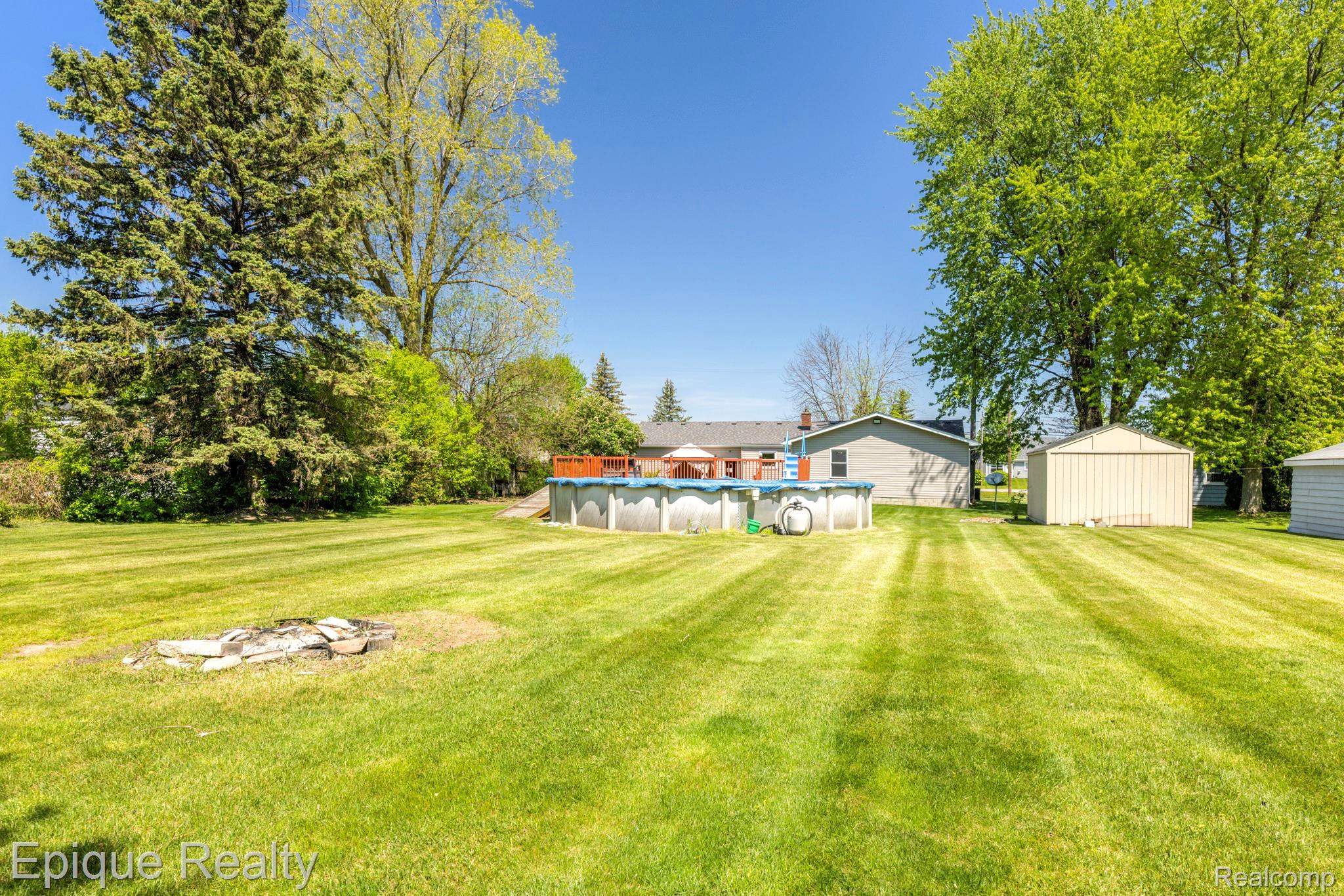 11110 Davison Road Davison, MI 48423 - Photo 58 of 65 View of green lawn featuring a covered pool and a storage unit