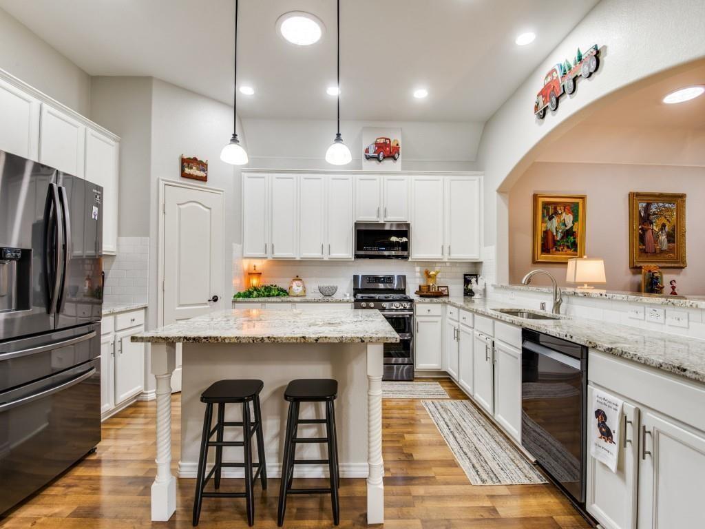 9962 Bell Rock Road Frisco, TX 75035 - Photo 8 of 28 a kitchen with stainless steel appliances granite countertop a stove top oven a refrigerator a sink and dishwasher with wooden floor