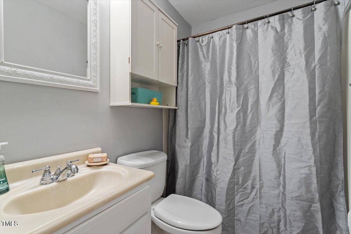 712 Godwin Court Raleigh, NC 27606 - Photo 20 of 27 a bathroom with a sink a toilet and shower curtain