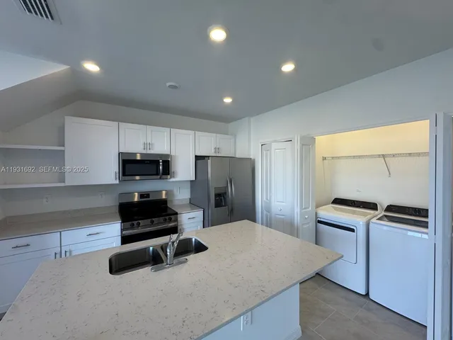 a kitchen with stainless steel appliances a stove a sink a refrigerator and cabinets