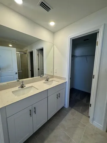 a bathroom with a double vanity sink and mirror