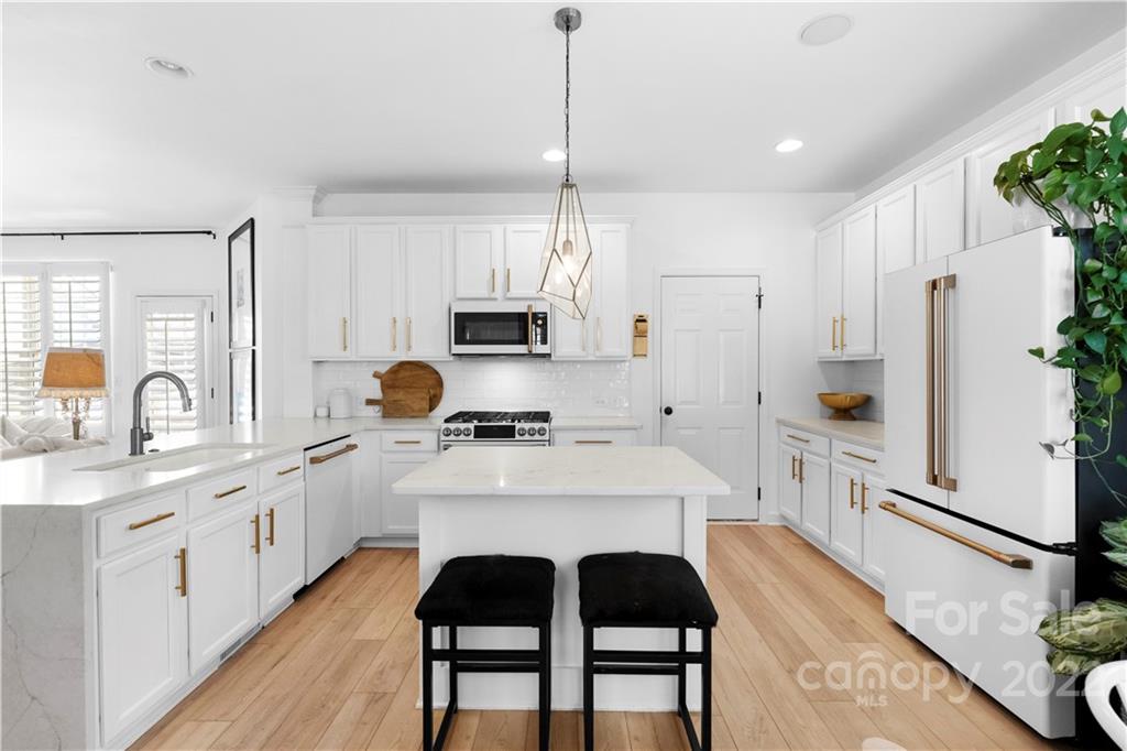 8106 Evanston Falls Road Huntersville, NC 28078 - Photo 3 of 36 a kitchen with white cabinets and stainless steel appliances