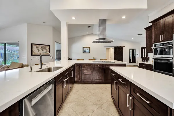 a large kitchen with stainless steel appliances lots of counter space and wooden floor