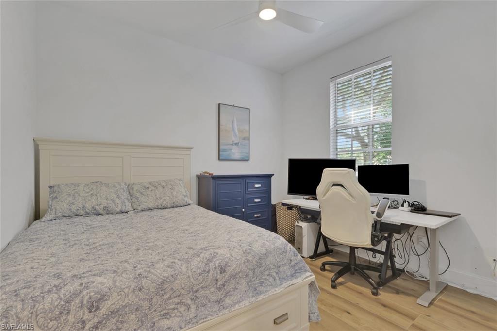 136 April Sound Drive Naples, FL 34119 - Photo 15 of 24 a bedroom with a bed and wooden floor