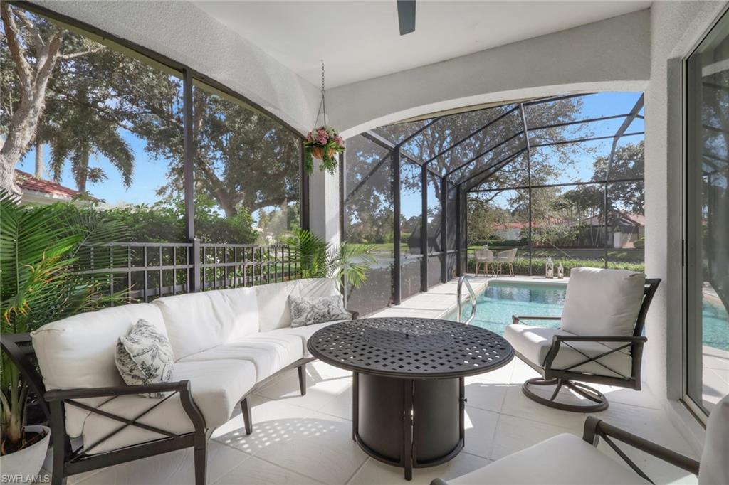 136 April Sound Drive Naples, FL 34119 - Photo 17 of 24 a view of a patio with a dining table and chairs