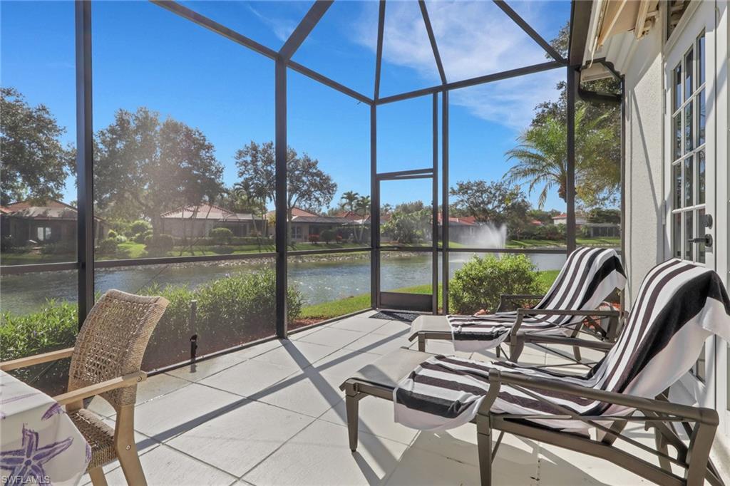 136 April Sound Drive Naples, FL 34119 - Photo 20 of 24 a view of swimming pool with a table and chairs under an umbrella