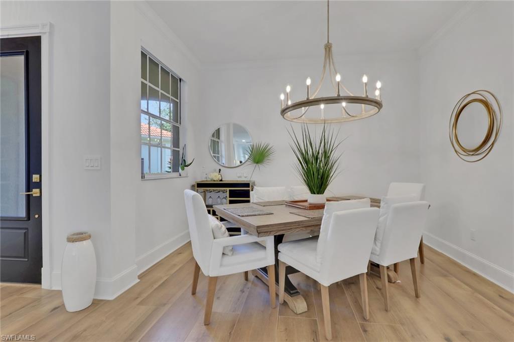 136 April Sound Drive Naples, FL 34119 - Photo 5 of 24 a view of a dining room with furniture a chandelier window and wooden floor