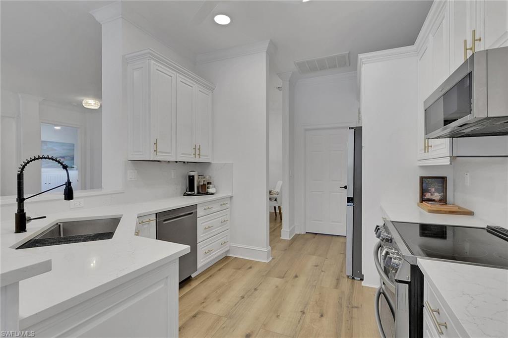 136 April Sound Drive Naples, FL 34119 - Photo 7 of 24 a kitchen with a sink a stove and refrigerator