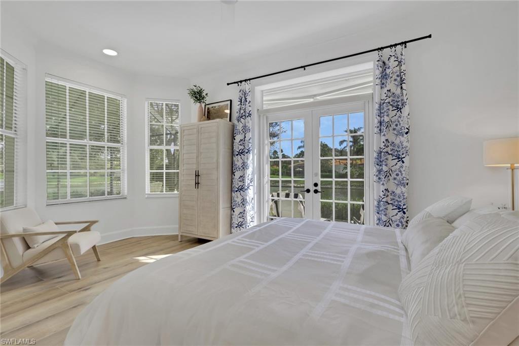 136 April Sound Drive Naples, FL 34119 - Photo 10 of 24 a bedroom with a bed and glass door