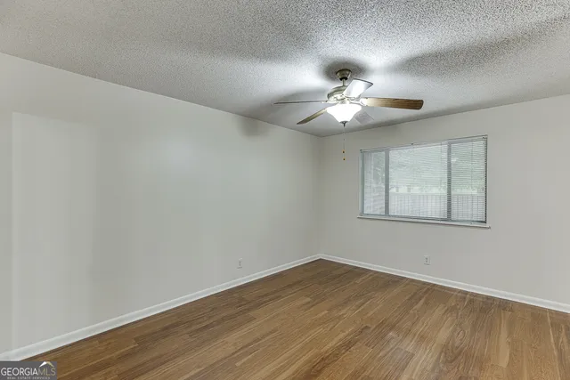 a view of a room with wooden floor and a ceiling fan