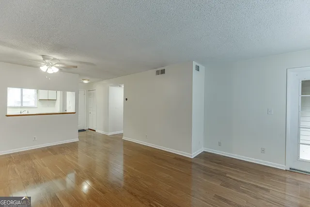 a view of an empty room with wooden floor