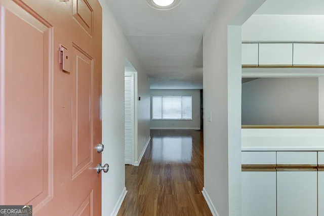 a view of a hallway with wooden floor and staircase