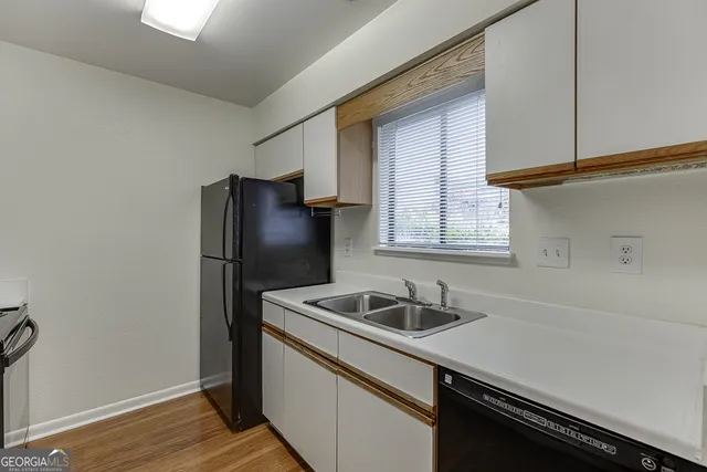 a kitchen with granite countertop a sink cabinets and stainless steel appliances