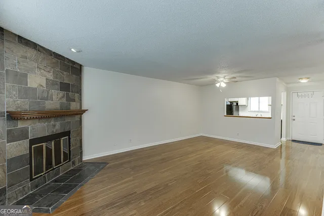 an empty room with wooden floor and fireplace