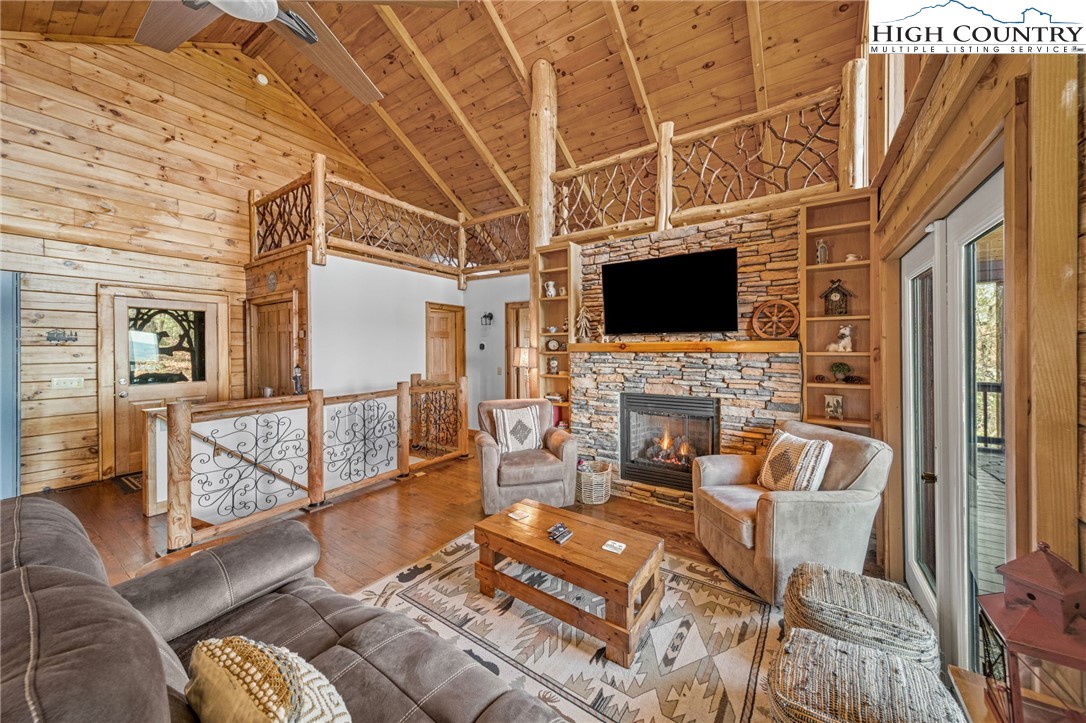 196 Eagle Nest Road Purlear, NC 28665 - Photo 14 of 36 a living room with furniture a fireplace and a flat screen tv