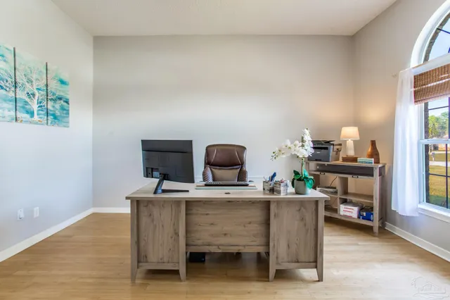 a view of a workspace with furniture and a window