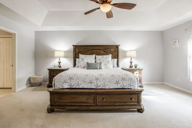 a spacious bedroom with a bed and a flat screen tv