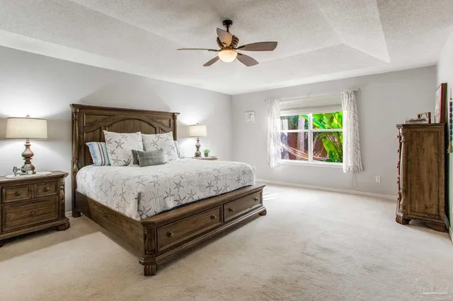 a bed room with a bed and a ceiling fan