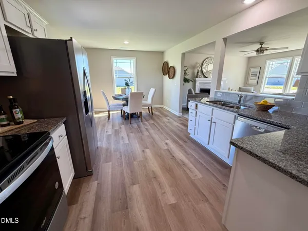 a kitchen with granite countertop a sink stove and refrigerator