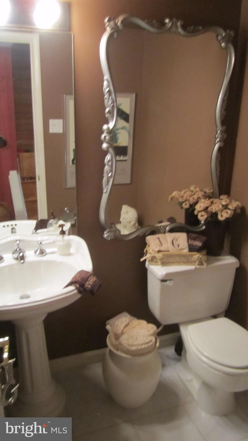 110 Cross Keys Road, Unit R110F Baltimore, MD 21210 - Photo 15 of 30 a bathroom with a sink a toilet and a mirror