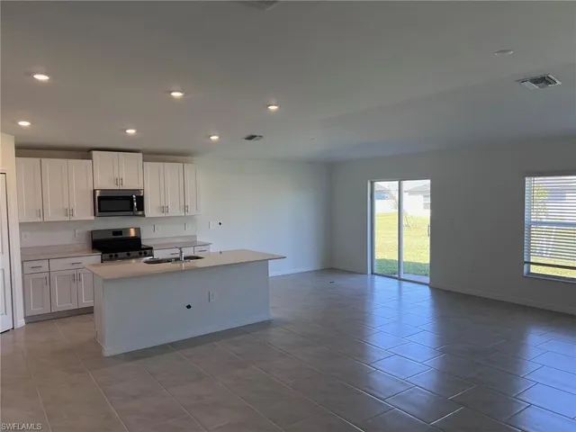 a kitchen with granite countertop a sink and cabinets