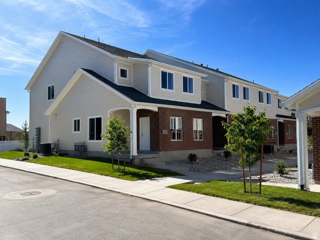 783 Pheasantbrook Drive, Unit 2A Centerville, UT 84014 - Photo 1 of 41 Contemporary townhome exterior featuring brick and light-toned siding, a covered entry, established sidewalks, and newly planted landscaping